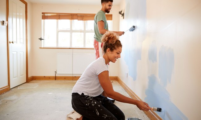 Two people painting an interior wall