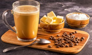 Coffee in glass cup with bowls of butter and MCT oil nearby
