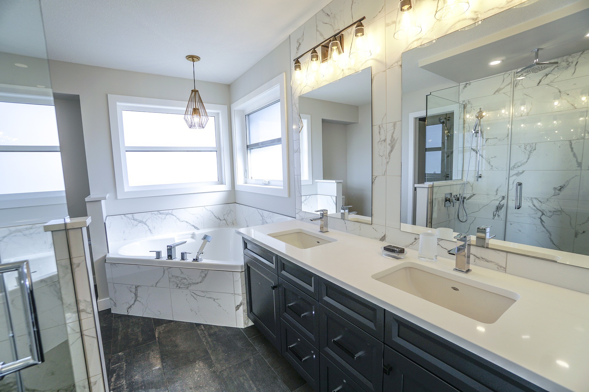 Bathroom with large sink, bathtub, and chandelier