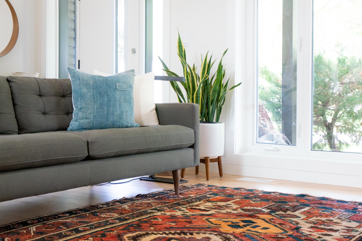 Gray sofa on multicolored rug