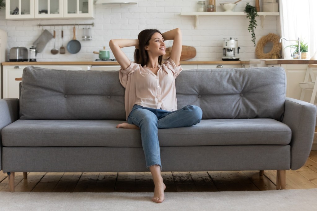 Woman sitting on a couch in a clean home