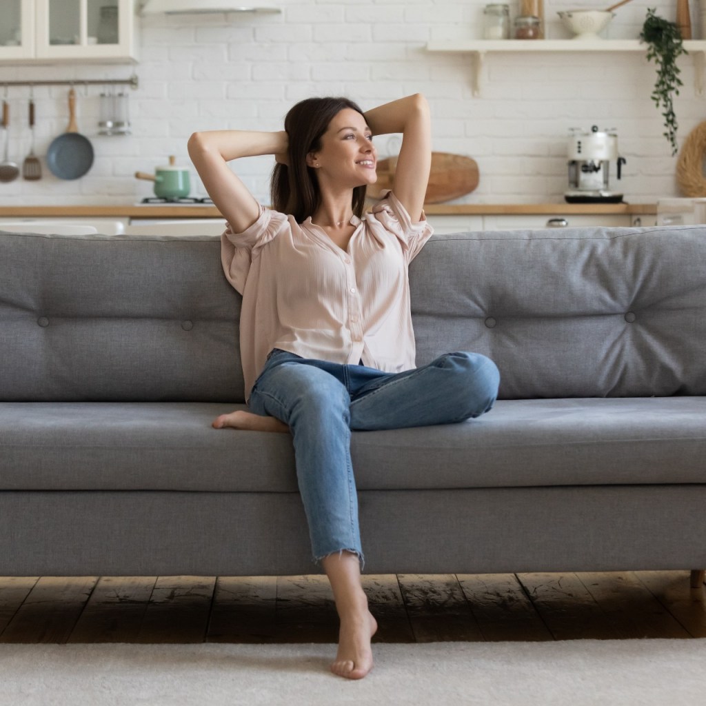 Woman sitting on a couch in a clean home