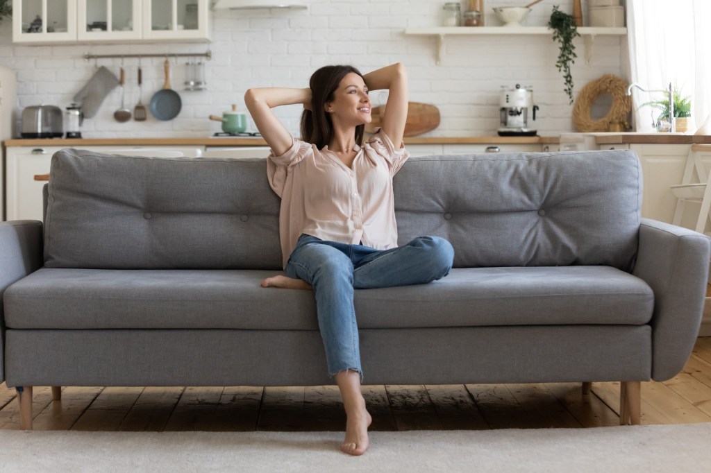 Woman sitting on a couch in a clean home