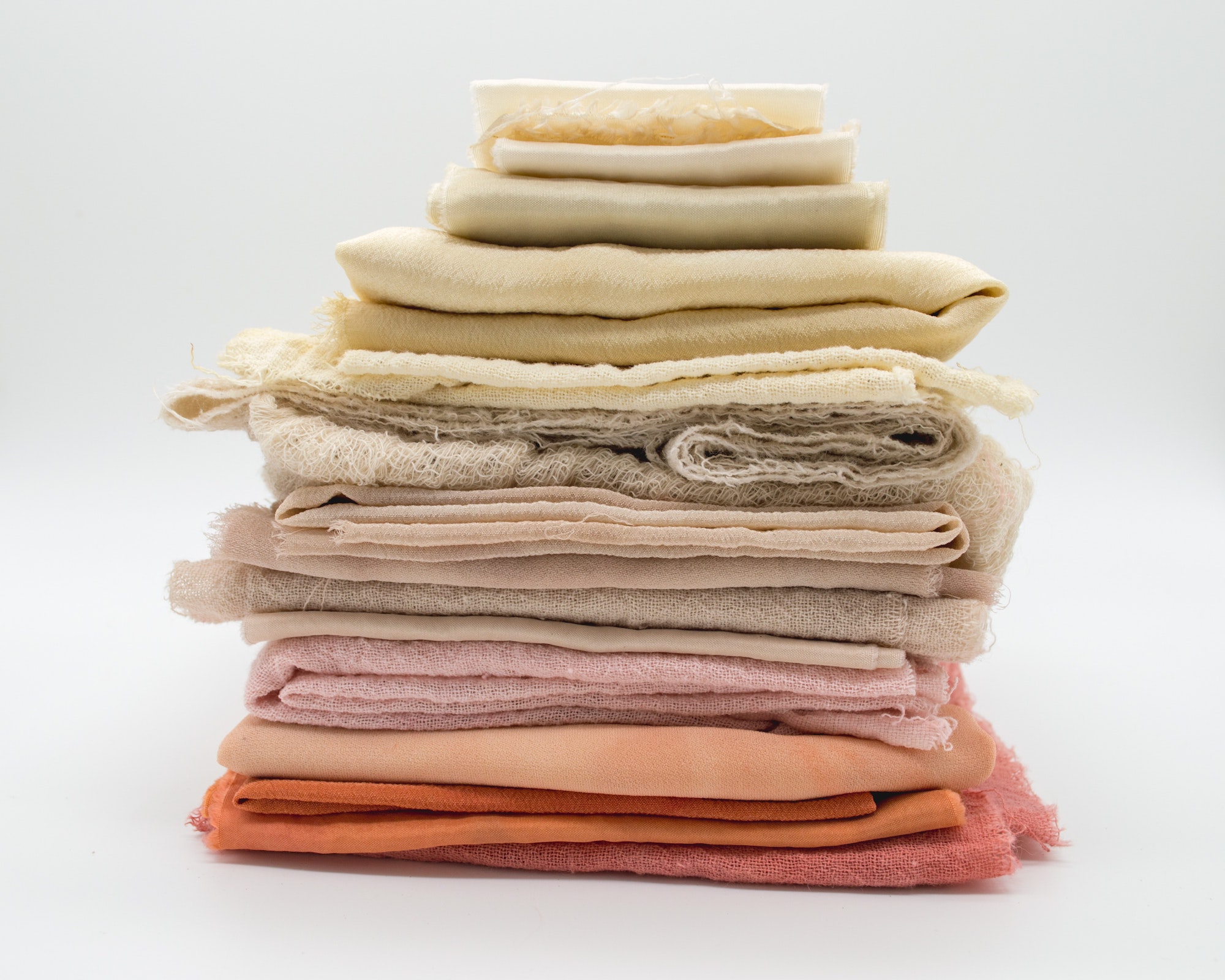 stack of different fabrics in various light colors