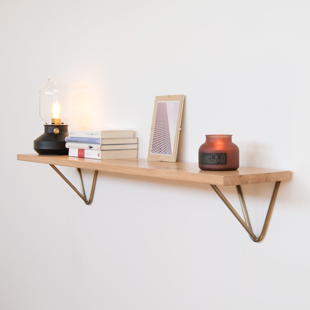 Wooden shelf with candles and other items on top.