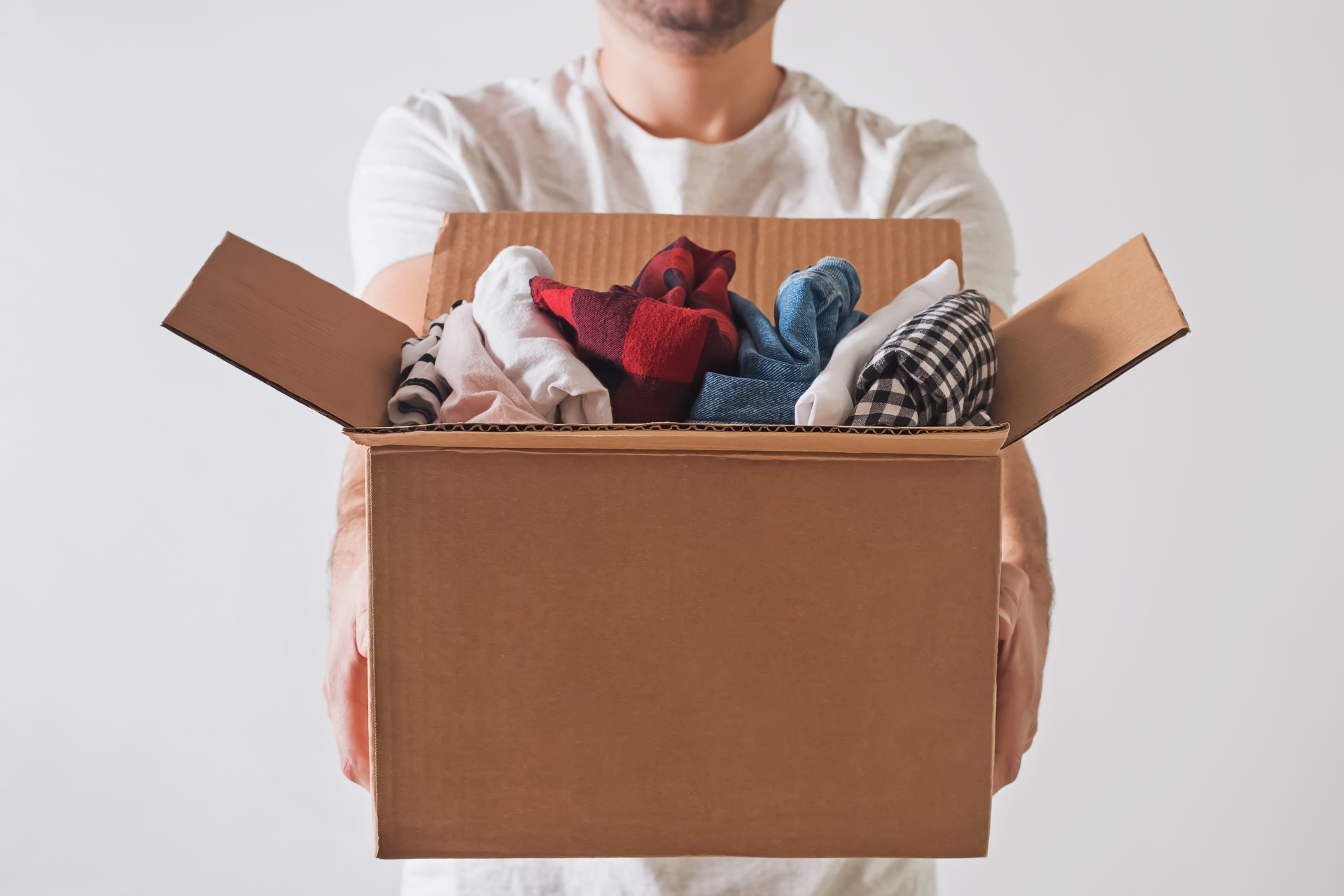 Man holding box of folded clothes