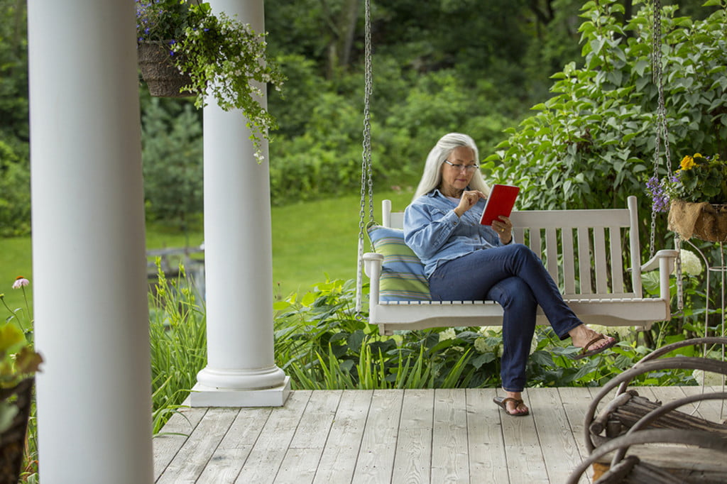 Woman reading on a front porch swing