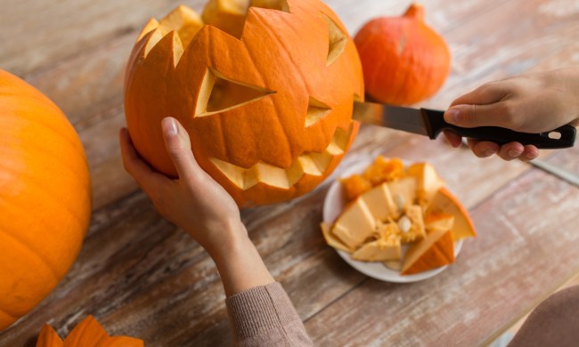 Person with knife cutting a pumpkin for Halloween
