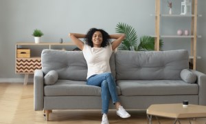 Young woman relaxing on cozy couch in new apartment
