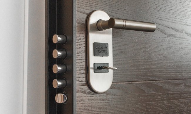 Wooden door with silver handle and multiple dead bolt locks