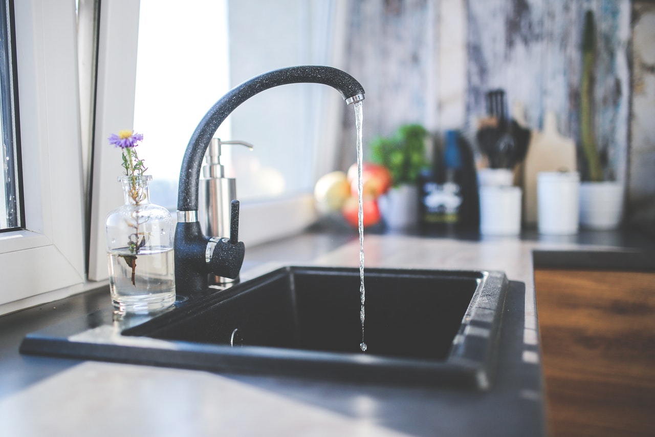 Black kitchen faucet with water running