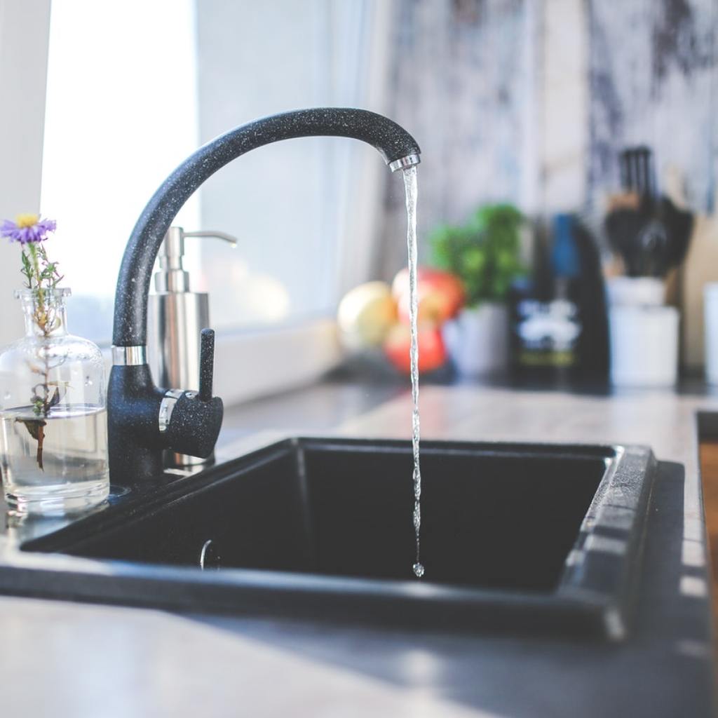 Black kitchen faucet with water running