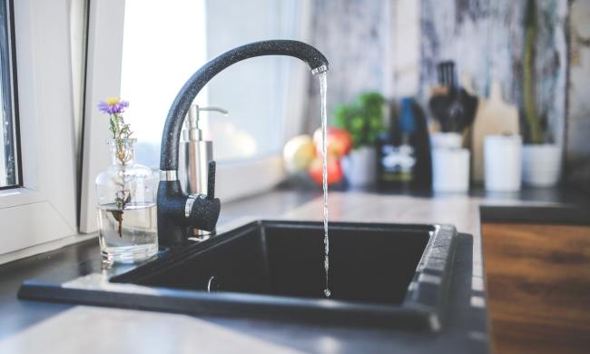 Black kitchen faucet with water running