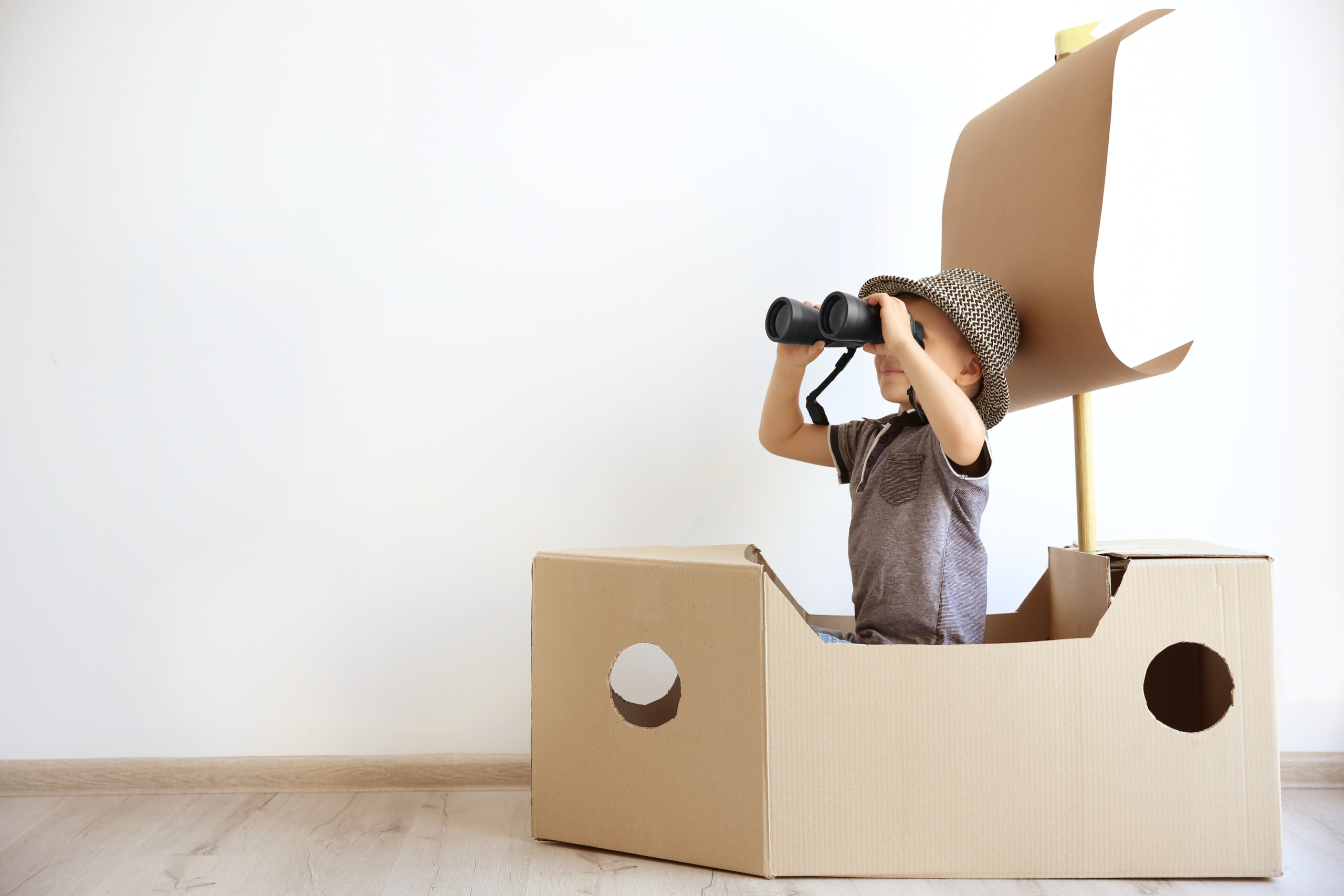 Child playing in a cardboard box