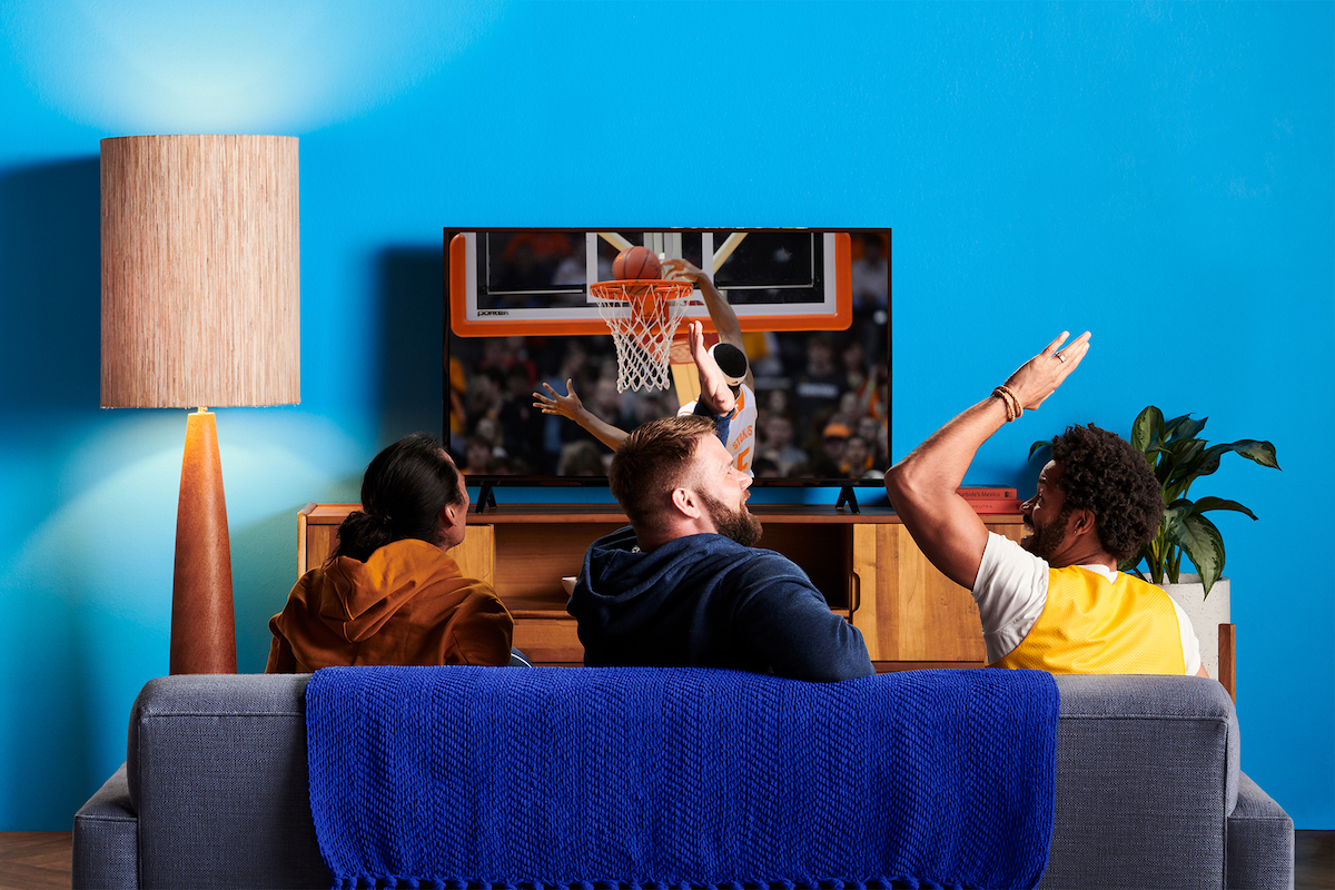 Three men watch a basketball game on TV