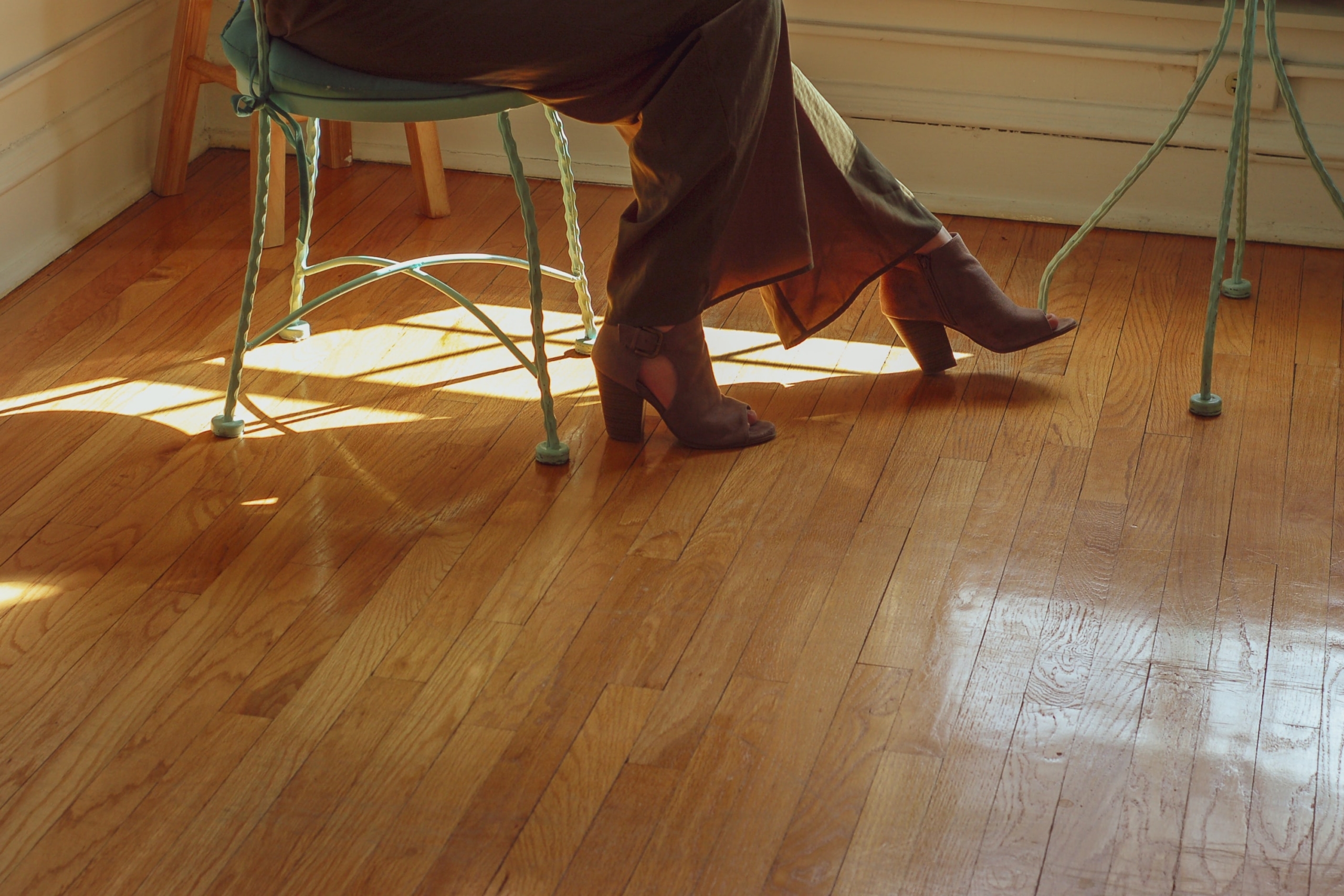 hardwood floor closeup with person in chair