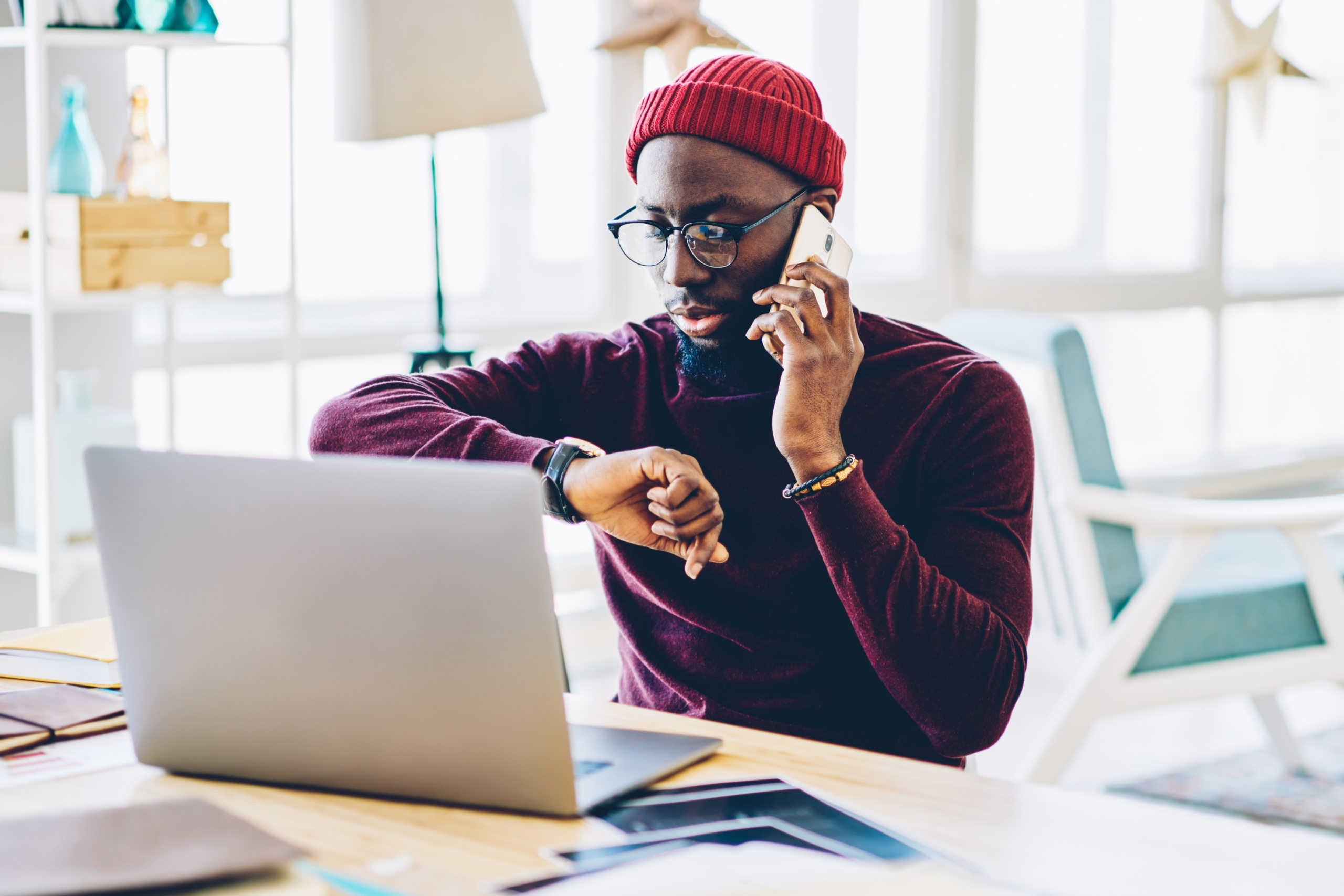 man at desk making a phone call with a laptop