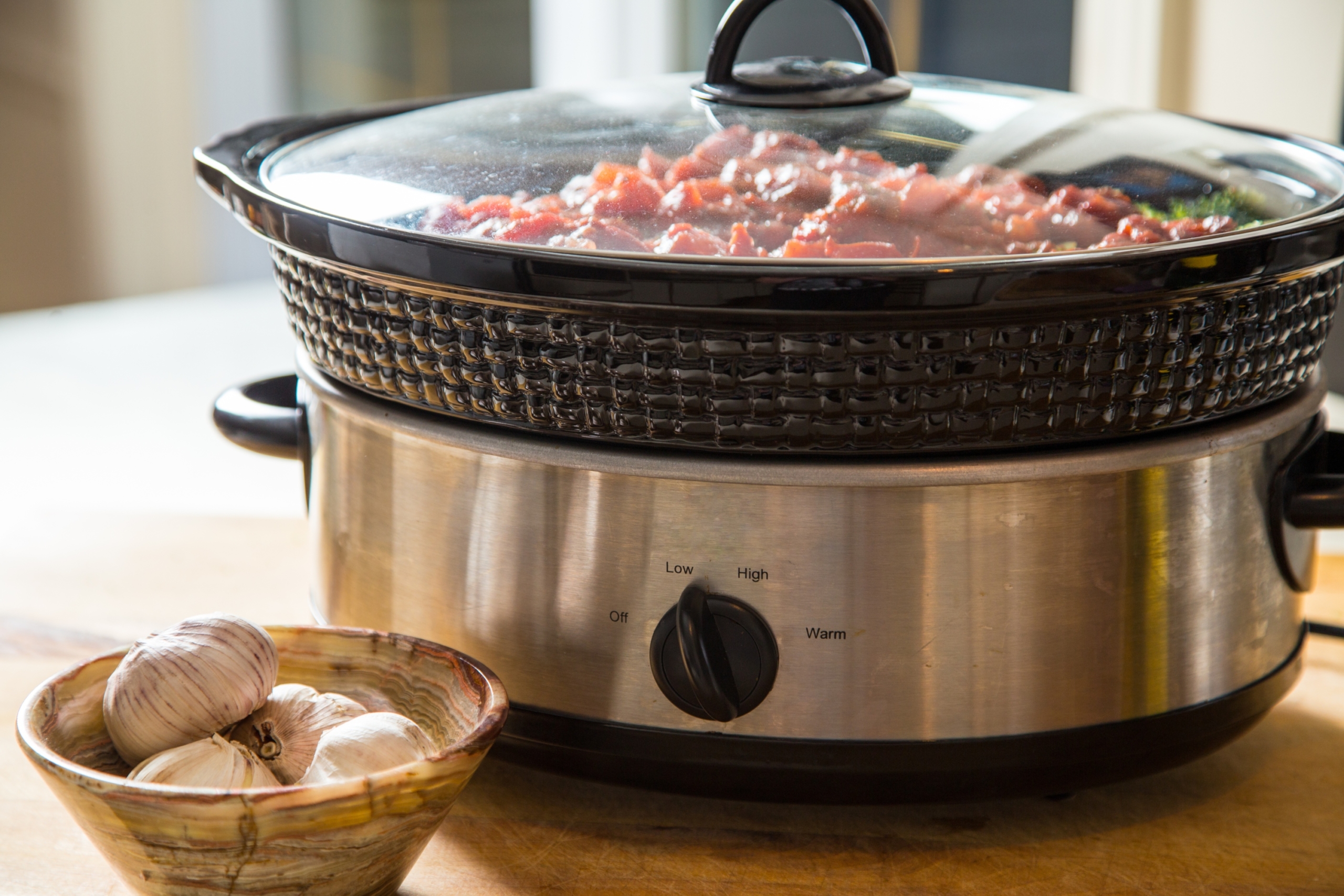 Slow cooker on a table with food