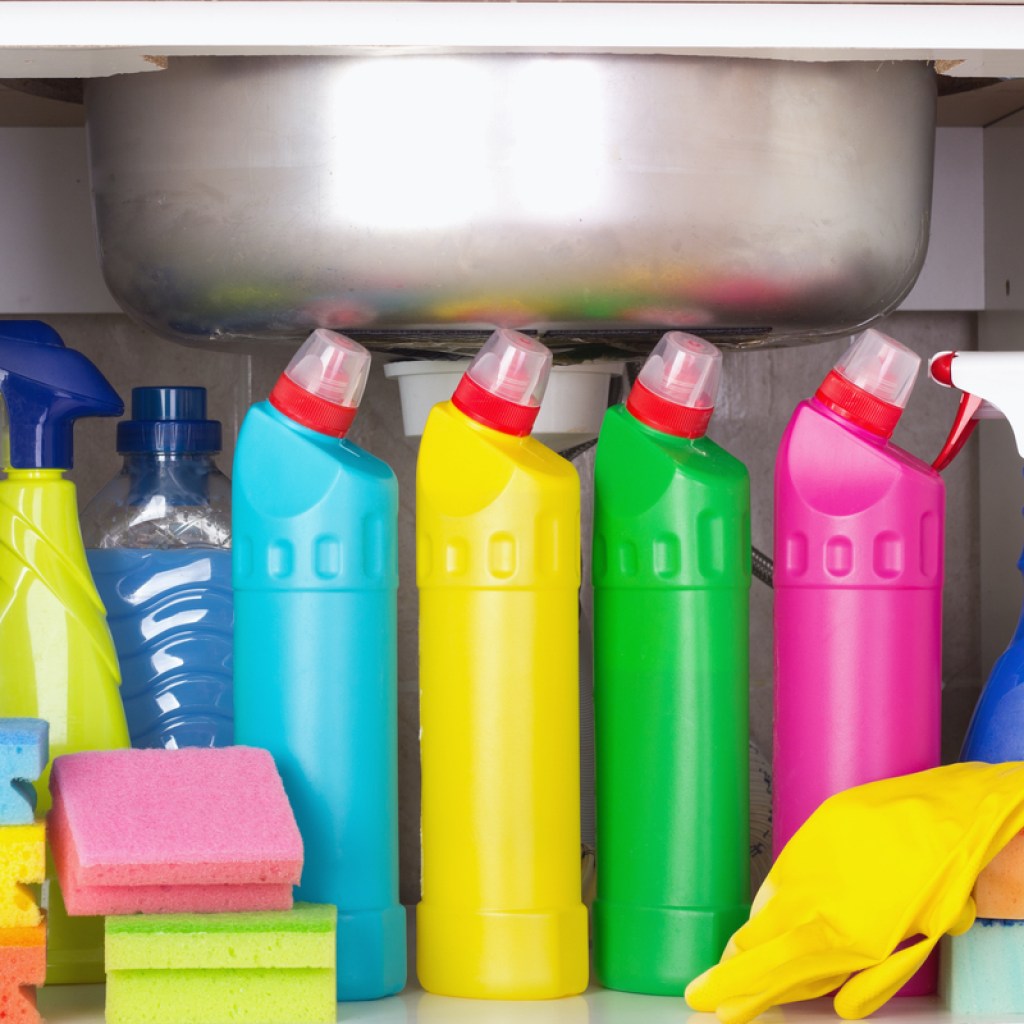 Several bottles of cleaning products under a sink