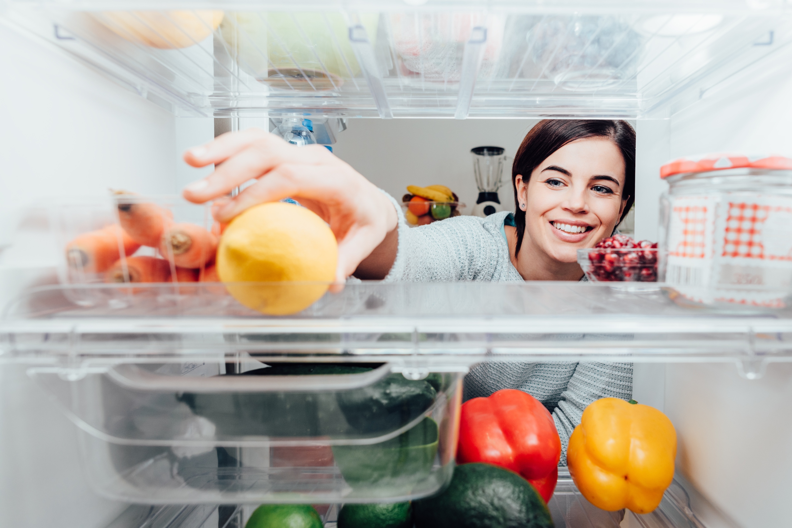 Woman opening fridge to get fruit