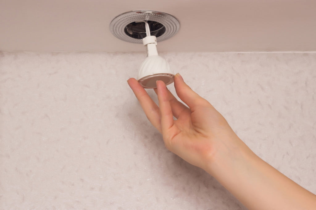 Person placing a recessed light into the ceiling