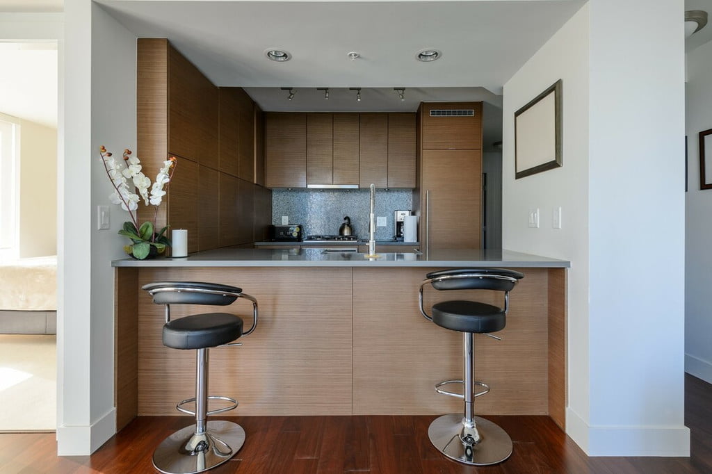 modern kitchen with wood cabinets and round bar stools