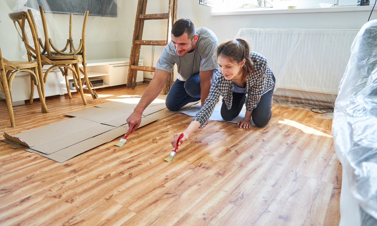 Couple staining a wood floor