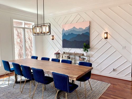 Modern dining room with blue chairs and rug.