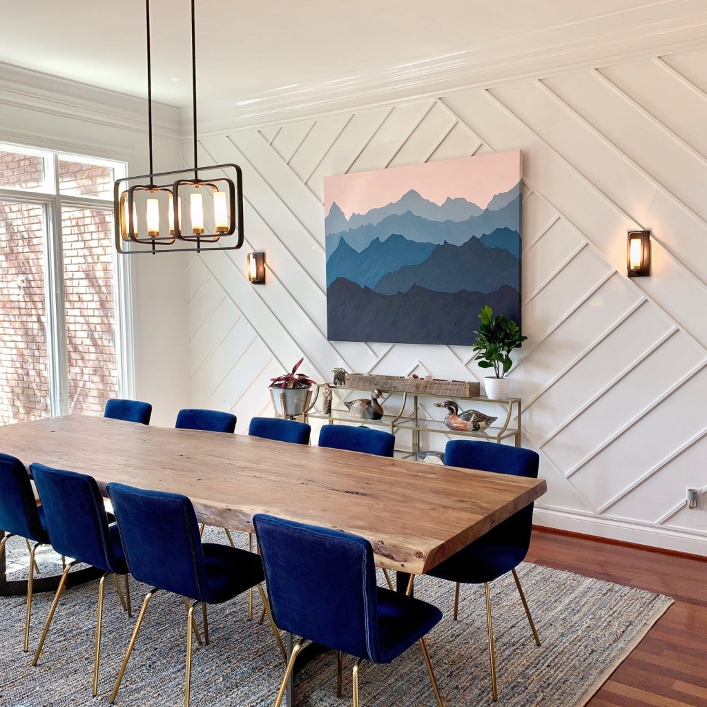 Modern dining room with blue chairs and rug.