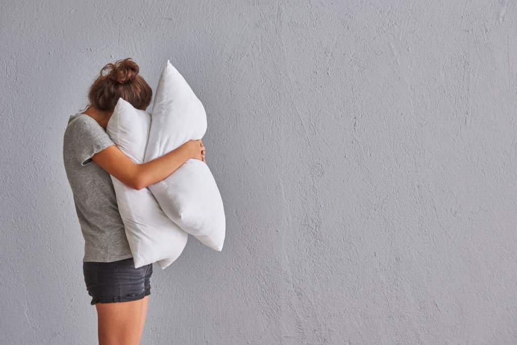 Woman hugs pillows