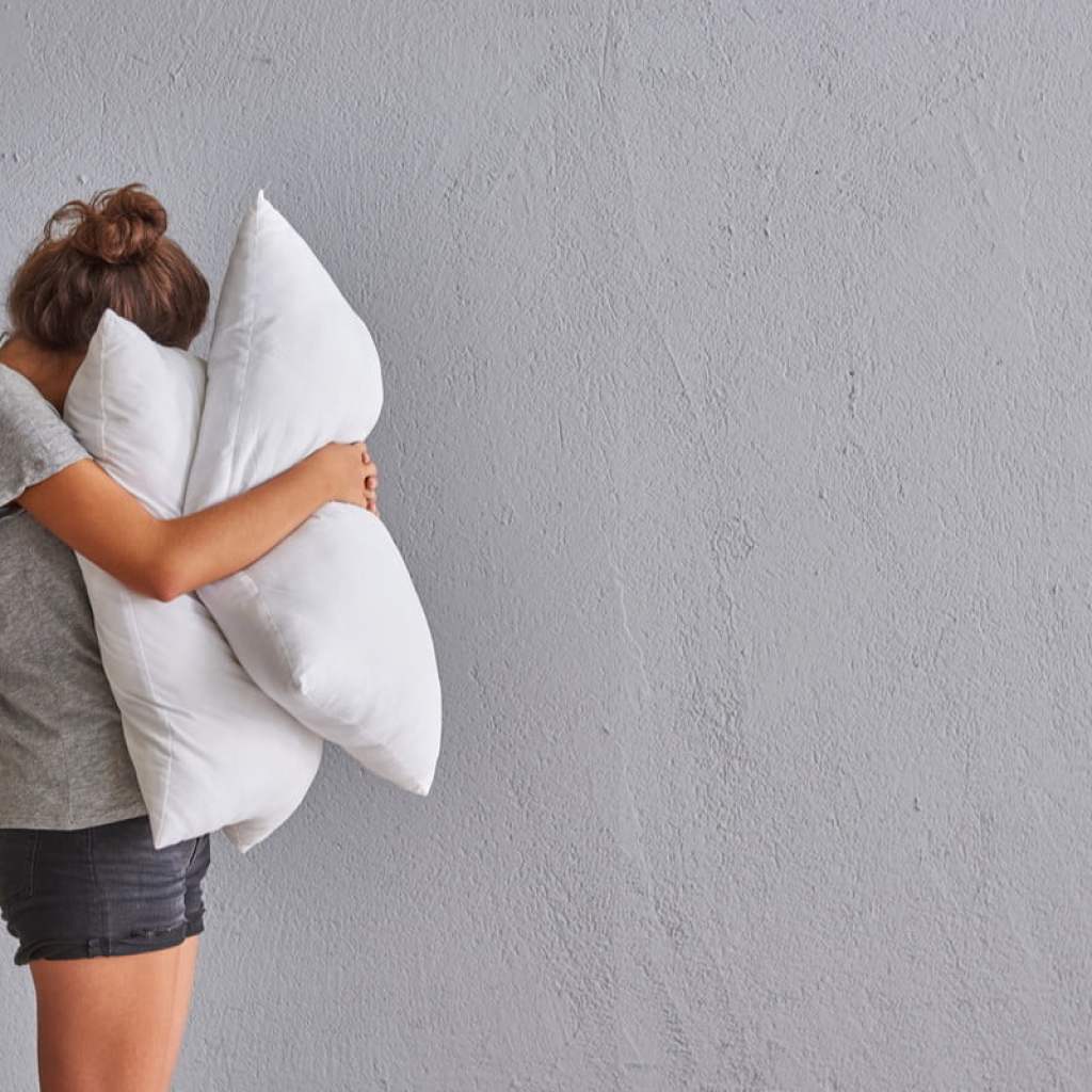 Woman hugs pillows