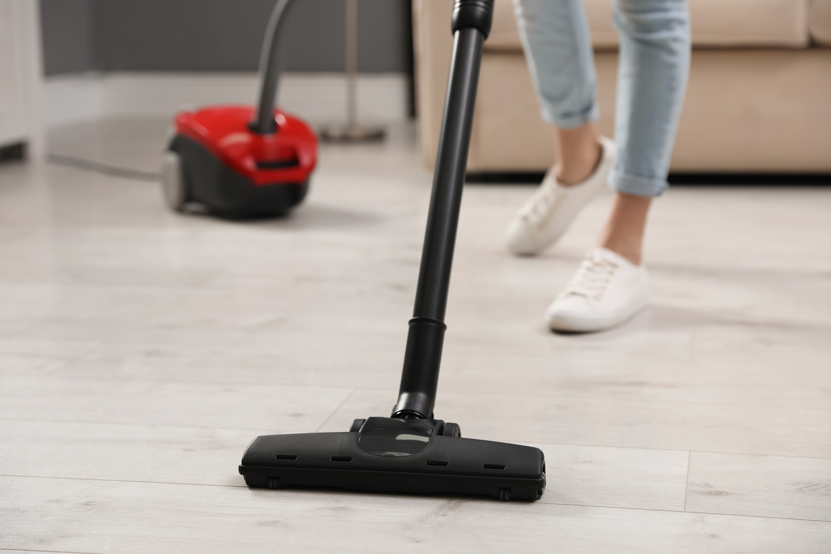 A woman vacuuming a hardwood floor