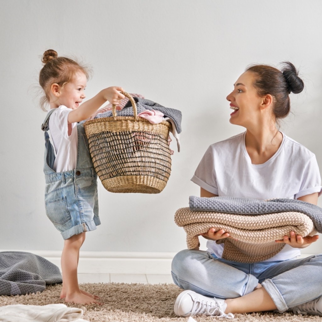 Child helping her mother with laundry