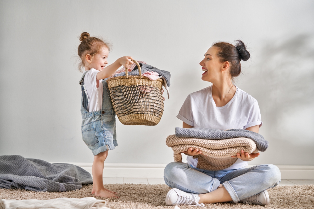 child helping her mother with laundry