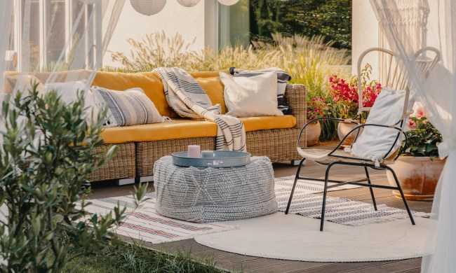Outdoor patio with furniture and framed by curtains