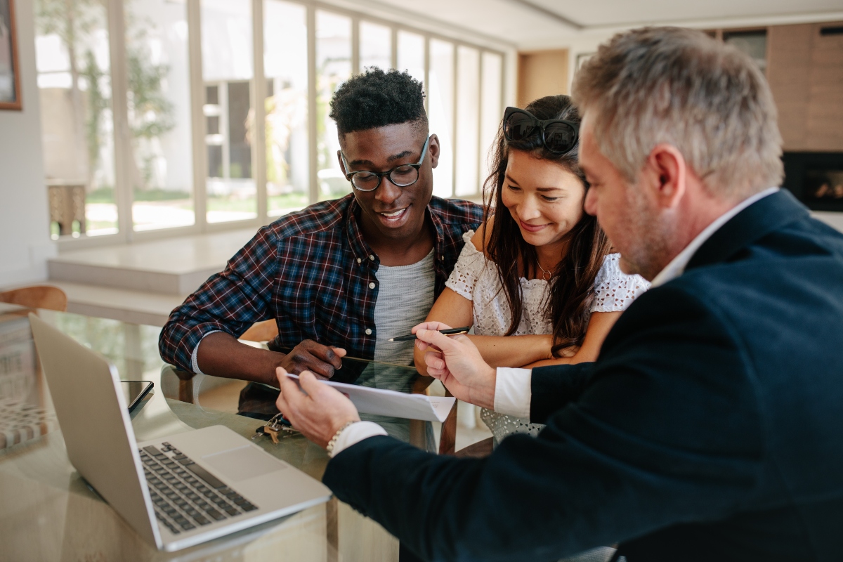 young couple talking with a real estate agent