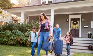 family carrying luggage and leaving home