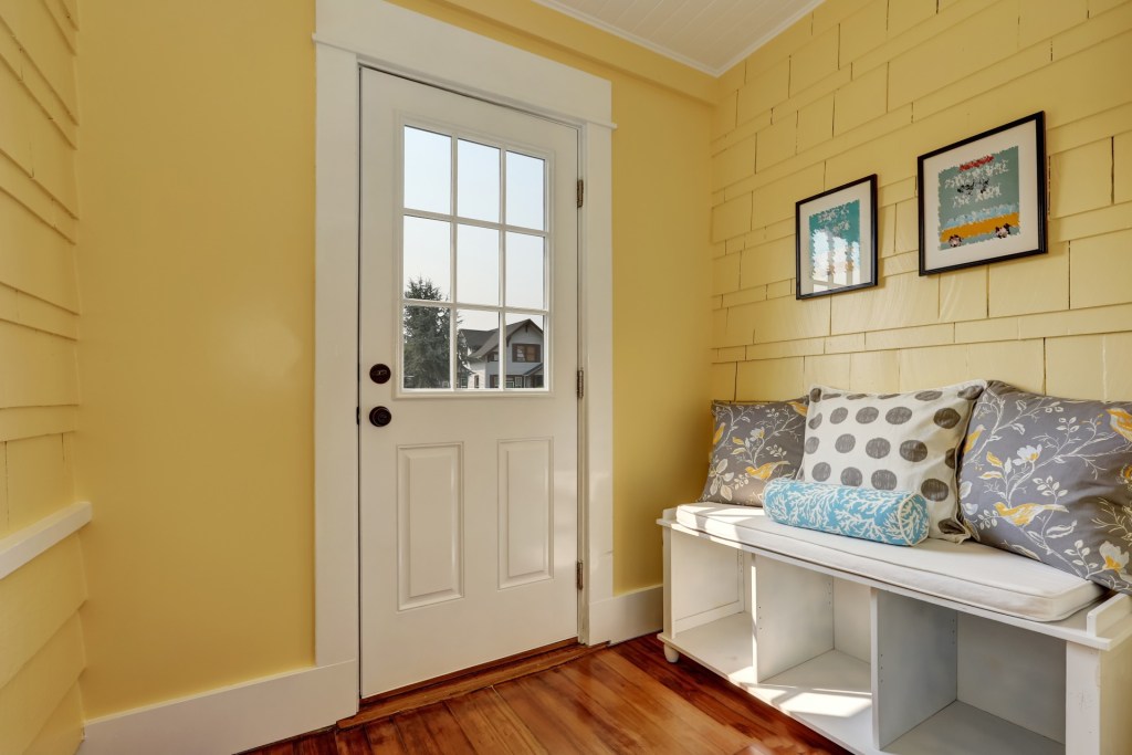 yellow entryway with bench
