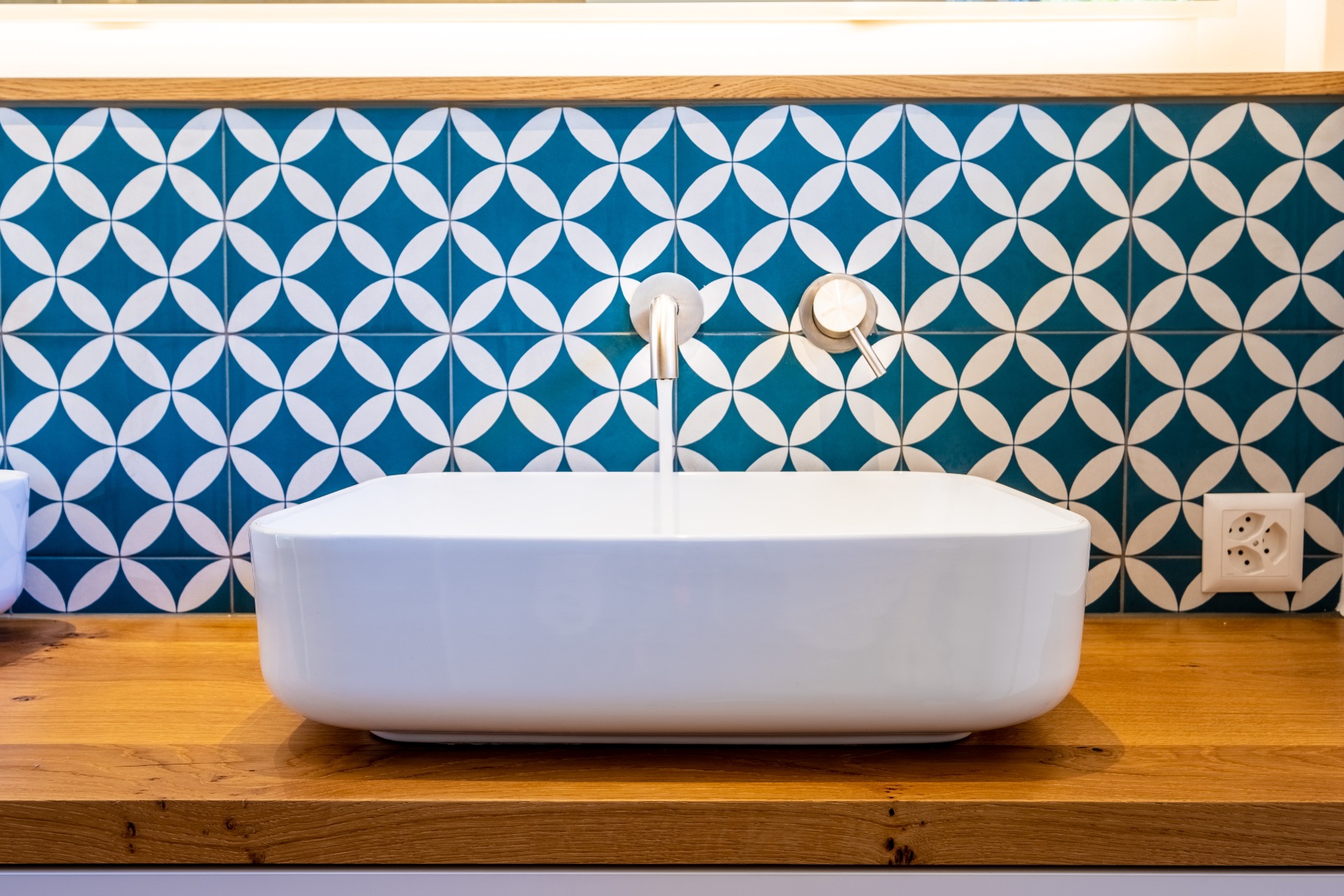 Blue and white tile behind the bathroom sink