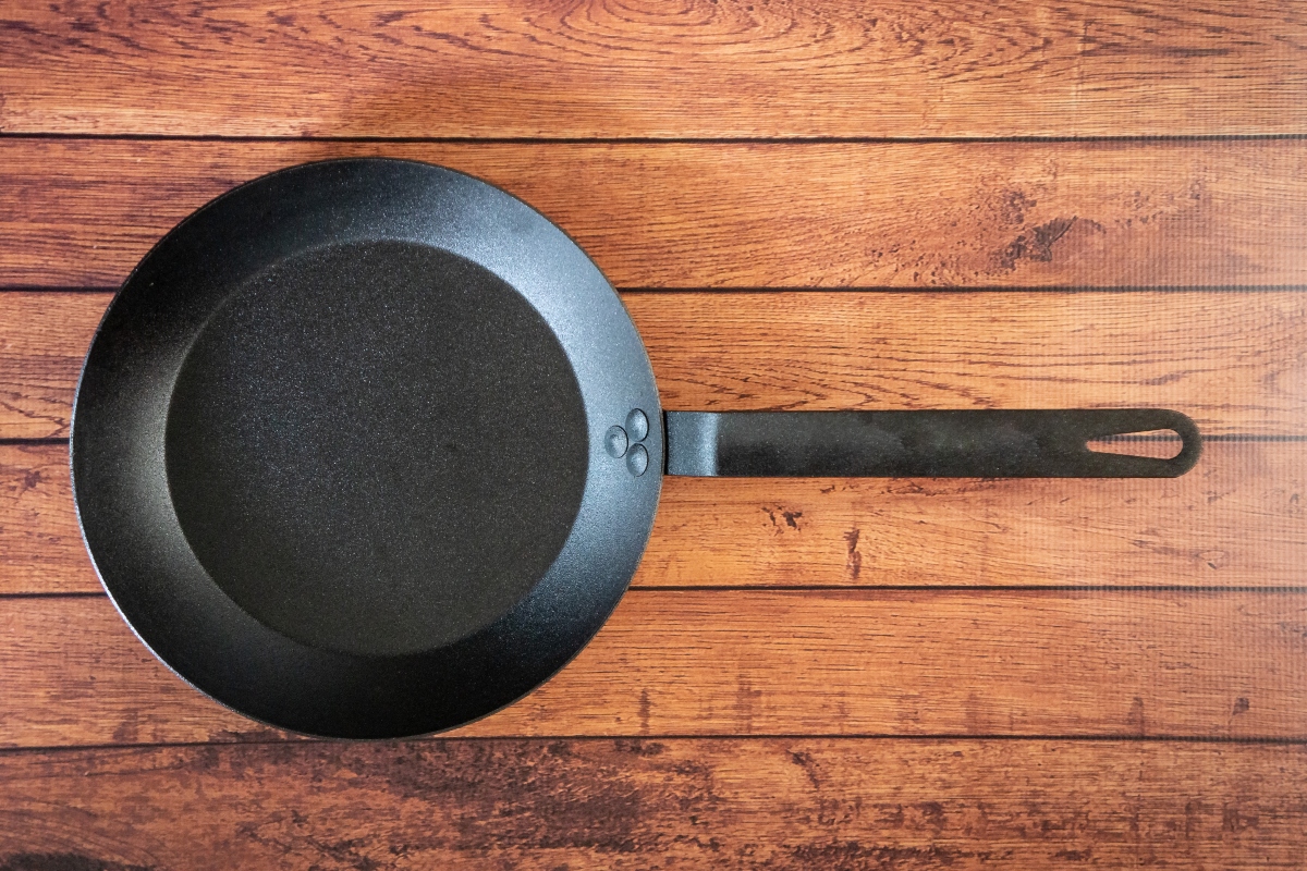 carbon steel frying pan on wood table