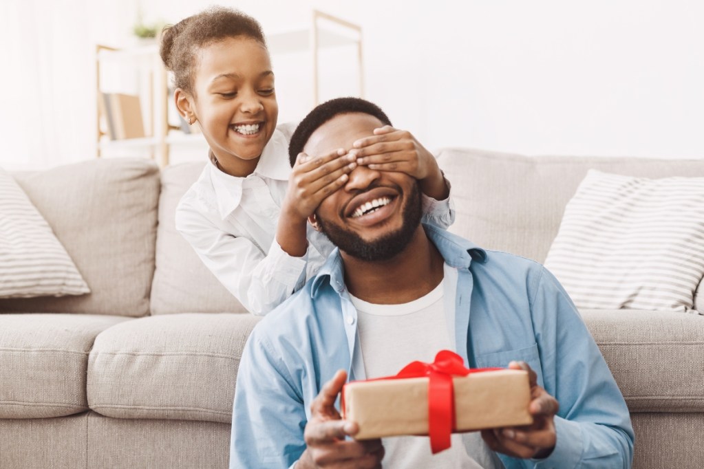 Girl surprising her dad with a Father's Day gift