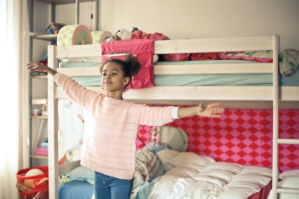 little girl standing in front of bunkbed