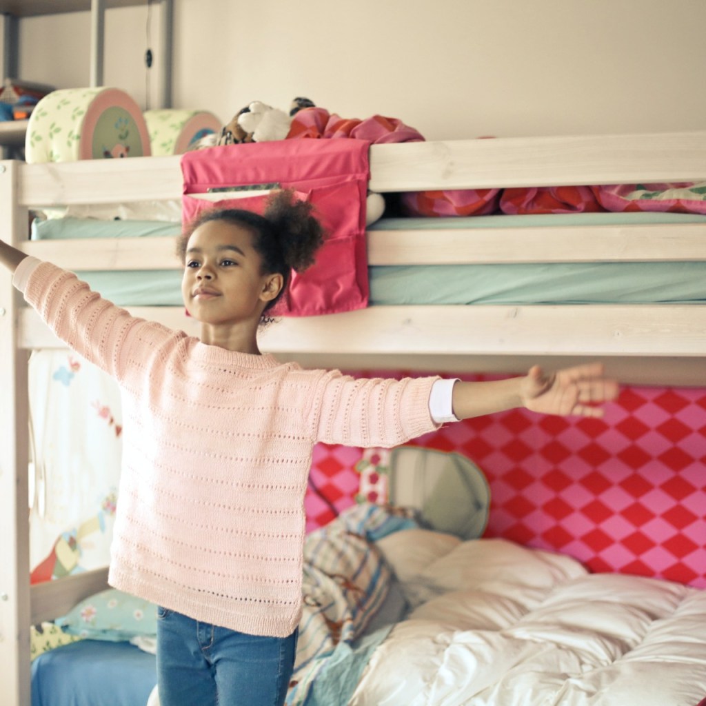 little girl standing in front of bunkbed