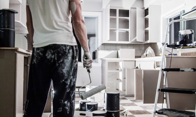 Man holding paint rolling after painting kitchen cabinets