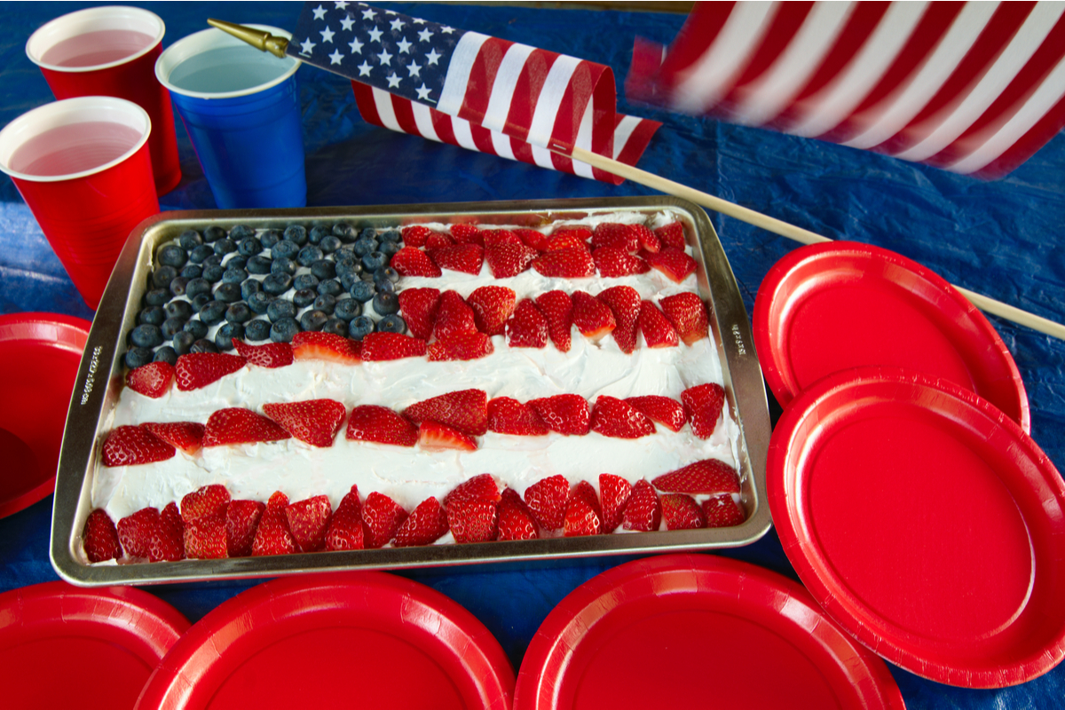 4th of july American flag sheet cake with red and blue cups and plates