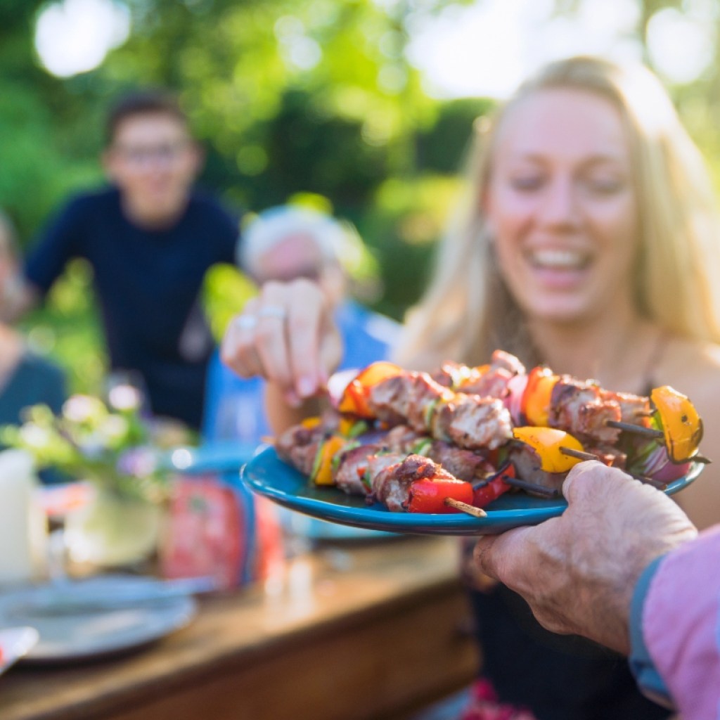 woman getting kababs at a dinner party