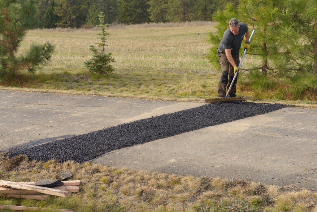 man repairing an asphalt driveway