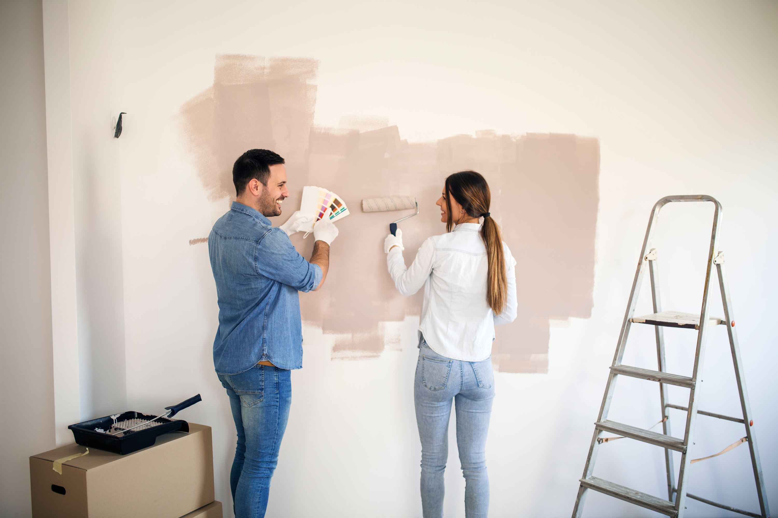 Couple Painting Neutral Colors On Wall