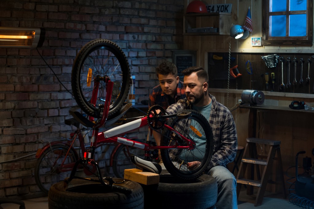 Dad and son working on a bike in the garage