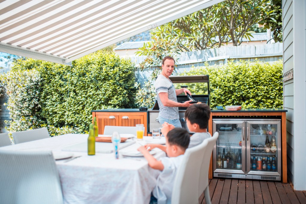 Dad and kids in covered outdoor kitchen area